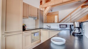 A modern kitchen with wooden cabinets, a stainless steel sink, and a coffee maker. - Modern 4 bed Chalet, Hot tub, Stunning views of Morzine, easy access to Avoriaz (Morzine)