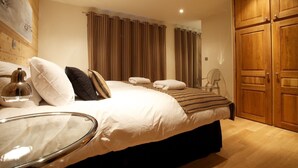 Camera da letto con un letto grande, un armadio in legno e uno specchio.