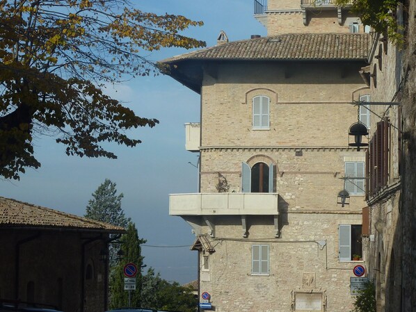 A multi-story building with a balcony, a window with shutters, and a no parking sign. - Attic in the center of Assisi (Assisi)