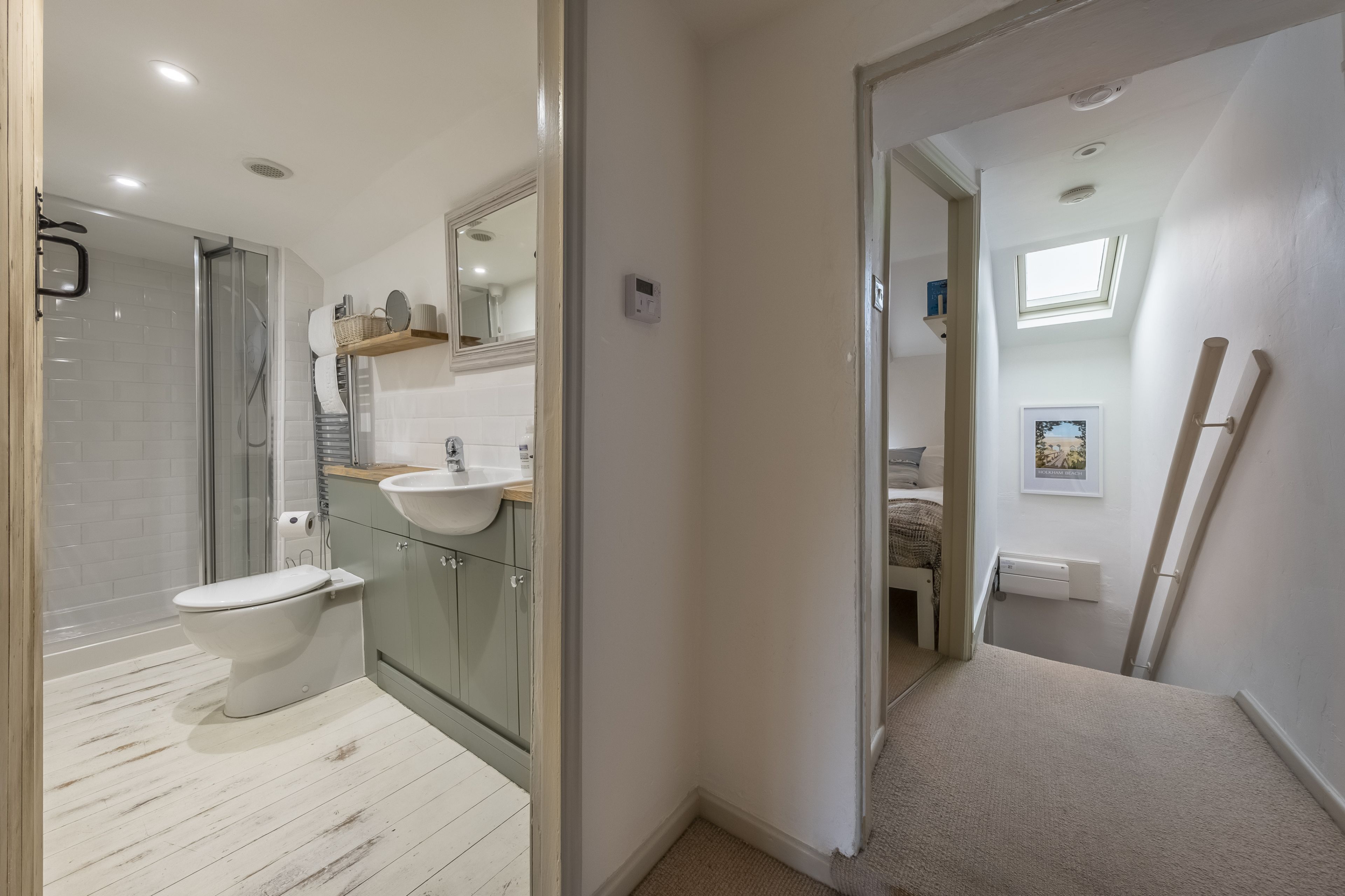 A modern bathroom with a glass shower enclosure, a white toilet, and a vanity with a sink and mirror.