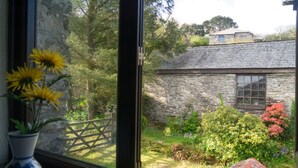 A stone house with a window and a garden. - Spacious Cottage With Sea Views (Trevillett)