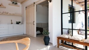 A modern interior with a wooden bench, a potted plant, and a large window. - Walking Distance to Platanias Centre and the Beach! Heated pool! (Chania)