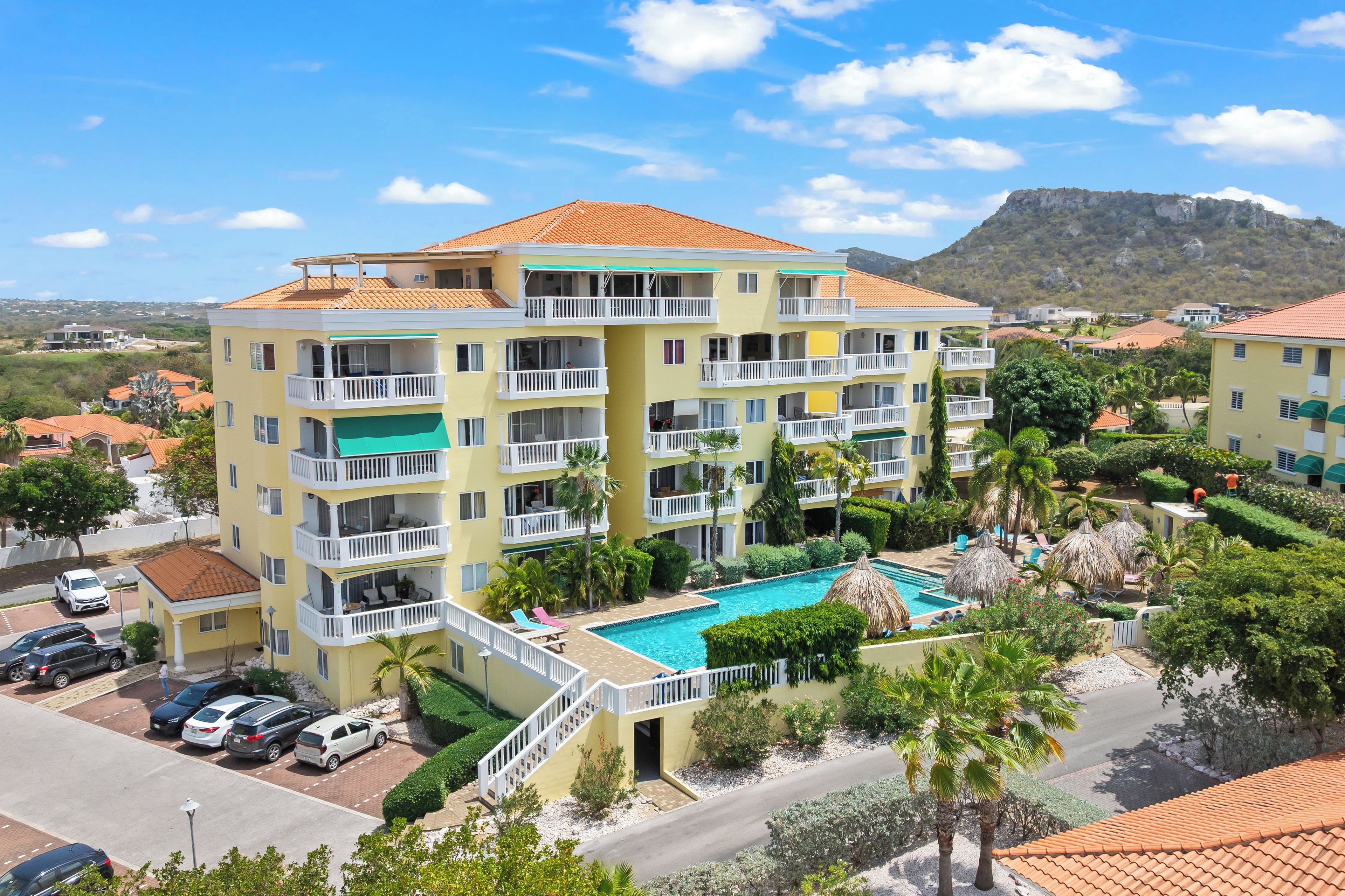 Un hôtel à plusieurs étages doté d’une piscine, de balcons et offrant une vue sur une montagne.