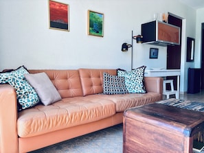 A living room with a sofa, a coffee table, and artwork on the wall.