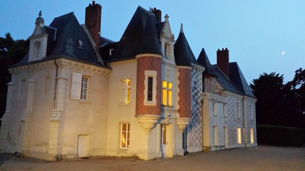 Un bâtiment historique doté de plusieurs tours et d’une façade symétrique.