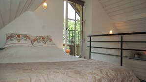 Ein Schlafzimmer mit einem Bett, einem Fenster und einem Metallregal.