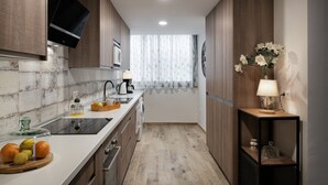 Une cuisine moderne avec des meubles en bois, un four encastré et une fenêtre avec des rideaux.