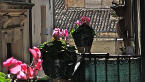 A balcony with potted plants and a street view.