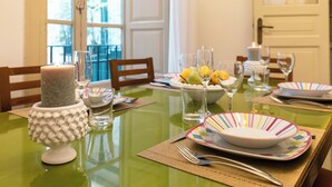 A dining table set with plates, glasses, and a candle.