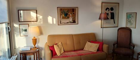 A living room with a sofa, a lamp, a chair, and a rug.