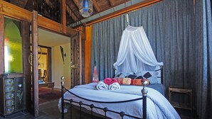 Ein Schlafzimmer mit Himmelbett, Baldachin und einem Vintage-Radio.