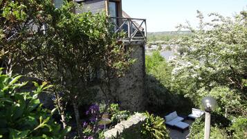 A stone wall with a garden in front of a house.