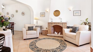 A living room with two sofas, a fireplace, and a round rug. - Villa Bia OCV - Private Pool (Albufeira)