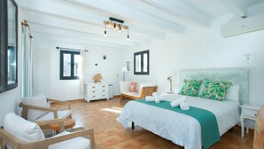 A spacious bedroom with a large bed, a wooden chair, a nightstand, and a dresser. - VILLA ALMADRAVA - VACATION PARADISE (Pollensa)