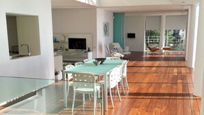 A modern living space with a dining area, kitchen, and a balcony with a view. - Spectacular Panoramic Views of Cap Ferrat & Beaulieu. (Villefranche-Sur-Mer)