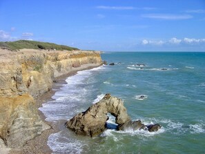 A coastal landscape with rocky cliffs, a clear blue sky, and waves crashing against the shore. - House / Villa - Jard sur mer (Jard-Sur-Mer)