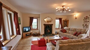 A cozy living room with a fireplace, a television, and comfortable seating.