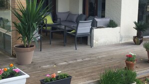 A wooden deck with outdoor furniture, potted plants, and a glass door leading to a room. - 40 meters from the beach, windows on the Arcachon "basin" (Arès)