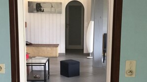 A room with a tiled floor, a black ottoman, a glass-top table, and a white lamp. - 40 meters from the beach, windows on the Arcachon "basin" (Arès)