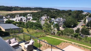 Un barrio residencial con casas, un sendero y vista al mar.