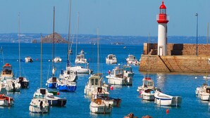 Un puerto con varios barcos amarrados cerca de un faro.