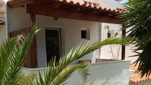A white building with a tiled roof and a covered patio area. - Rustic house, sea view, 6 people, terrace with barbecue.  (Sesimbra)
