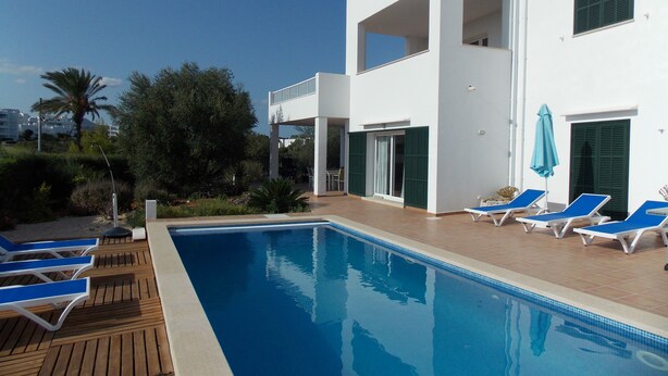 A modern two-story building with a swimming pool, outdoor seating, and a view of the surrounding landscape. - New Villa With Private  Pool At Walking Distance From The Centre/Beach (Santanyí)