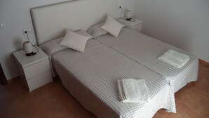 A neatly made twin bed with a patterned bedspread and pillows, two bedside tables with lamps, and a tiled floor. - New Villa With Private  Pool At Walking Distance From The Centre/Beach (Santanyí)