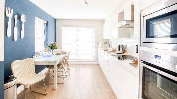 A modern kitchen with white cabinetry, a built-in oven, and a microwave. - Northern Hideaways Seascape (Seahouses)