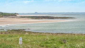 Overlooking the serene coastal landscape, this property offers breathtaking views of the sandy beach and the distant lighthouse.