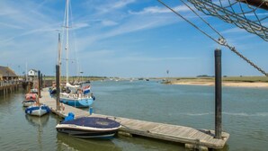Un port de plaisance où plusieurs bateaux sont amarrés à des quais en bois.