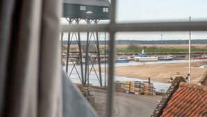 Une vue d’une zone côtière avec un quai, des bateaux et un bâtiment doté d’un toit végétalisé.