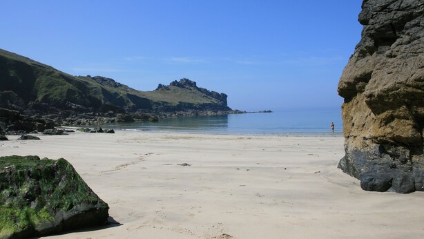 A beach with a rocky cliff and a person standing in the distance. - Holiday cottage with beautiful views over the Cornish sea (St Ives)