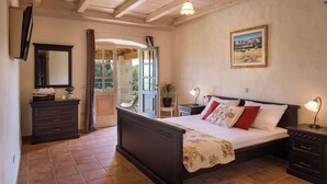 Un dormitorio con una cama de madera, una mesita de noche, un aparador, un espejo y un cuadro en la pared.