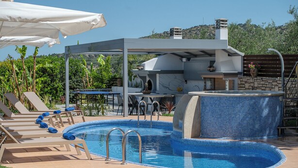 Ein Poolbereich mit Liegestühlen, einem Grill und einem gefliesten Whirlpool.
