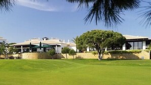 Un terrain de golf avec un bâtiment en arrière-plan.