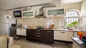Une cuisine moderne dotée d’appareils électroménagers intégrés, d’un téléviseur à écran plat et d’une fenêtre offrant une vue agréable.