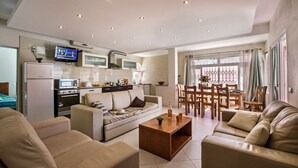 Un salon moderne avec un canapé, une table basse et un téléviseur fixé au mur.