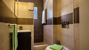 Een bad/douchecombinatie, een haardroger, een bidet, handdoeken