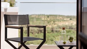 A chair and a small table with a bottle and glasses on a balcony with a view. - Tsourlakis Residence, A Tranquil Family Oasis with Pool (Rethymno)
