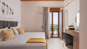 A bedroom with a bed, a desk, and a balcony with a view. - Tsourlakis Residence, A Tranquil Family Oasis with Pool (Rethymno)