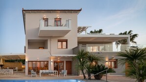 A modern two-story house with a swimming pool, outdoor seating, and a balcony. - Tsourlakis Residence, A Tranquil Family Oasis with Pool (Rethymno)