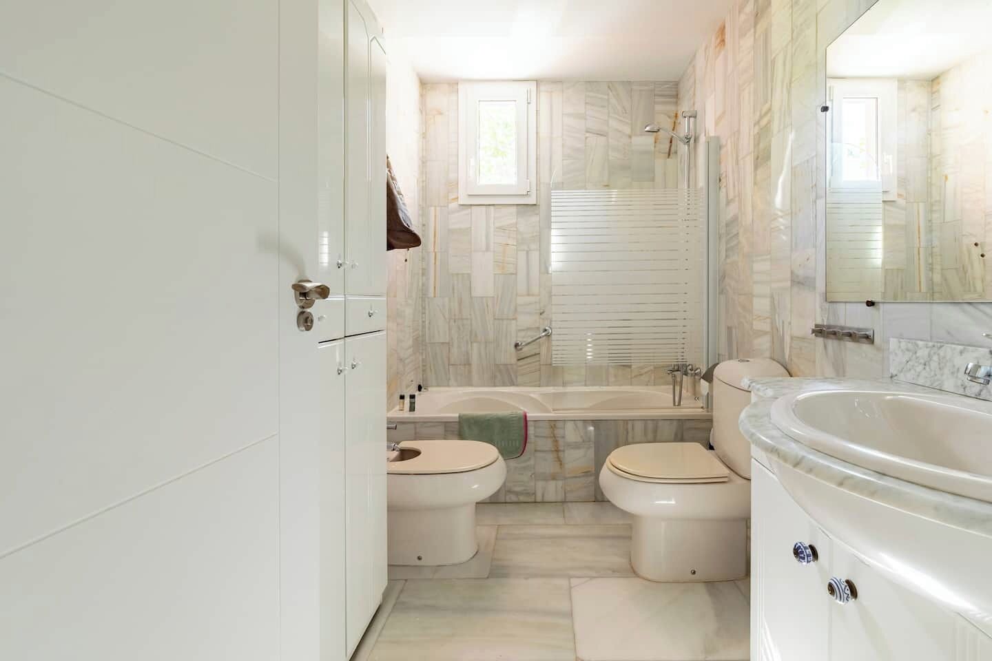 Kombination af bruser/badekar, hårtørrer, bidet, håndklæder