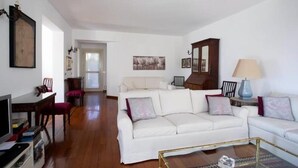 A living room with a white sofa, a glass coffee table, and a wooden cabinet. - House / Villa - Lecco (Lecco)