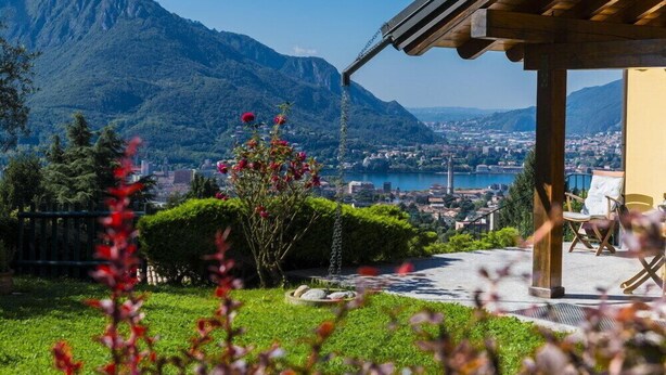 A terrace with a view of a lake and mountains, wooden pergola, and outdoor seating. - House / Villa - Lecco (Lecco)