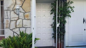 Una casa con fachada de piedra, puerta de garaje blanca y una lámpara colgante en forma de estrella.