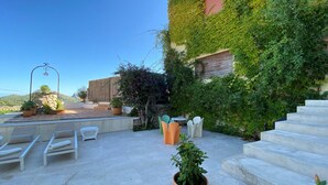 A rooftop patio with outdoor seating, a staircase, and potted plants. - Villa in Uptown Pollensa with spectacular views and private pool (Pollença)