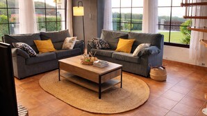A living room with two grey sofas, a wooden coffee table, and a woven rug. - Casa Charo with spectacular views of the sea (Cuchía, Miengo)
