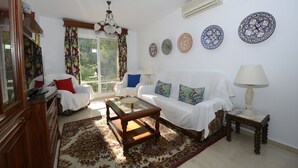 Un salon avec un canapé, une table basse et des assiettes décoratives accrochées au mur.