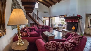 A cozy living room with a fireplace, plush seating, and a staircase leading to an upper level. - A/C 4 bedroom Villa, Pool, sea views beach 6 minutes walk.  Sleeps 8 people. (Pula)